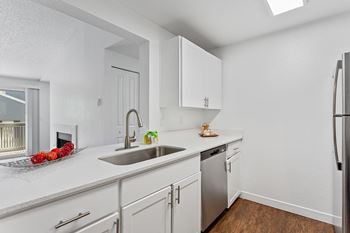 A kitchen with white cabinets and a stainless steel refrigerator. at Cedar Crest, Beaverton, Oregon